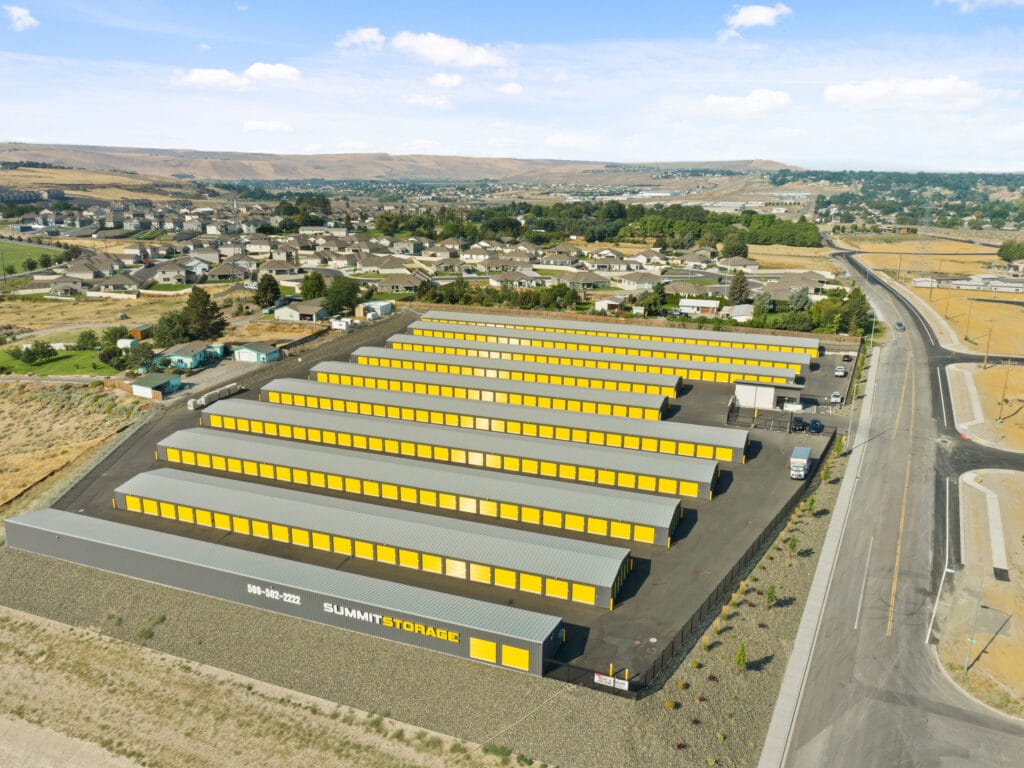 Aerial view of yellow-roofed storage facility near neighborhood.