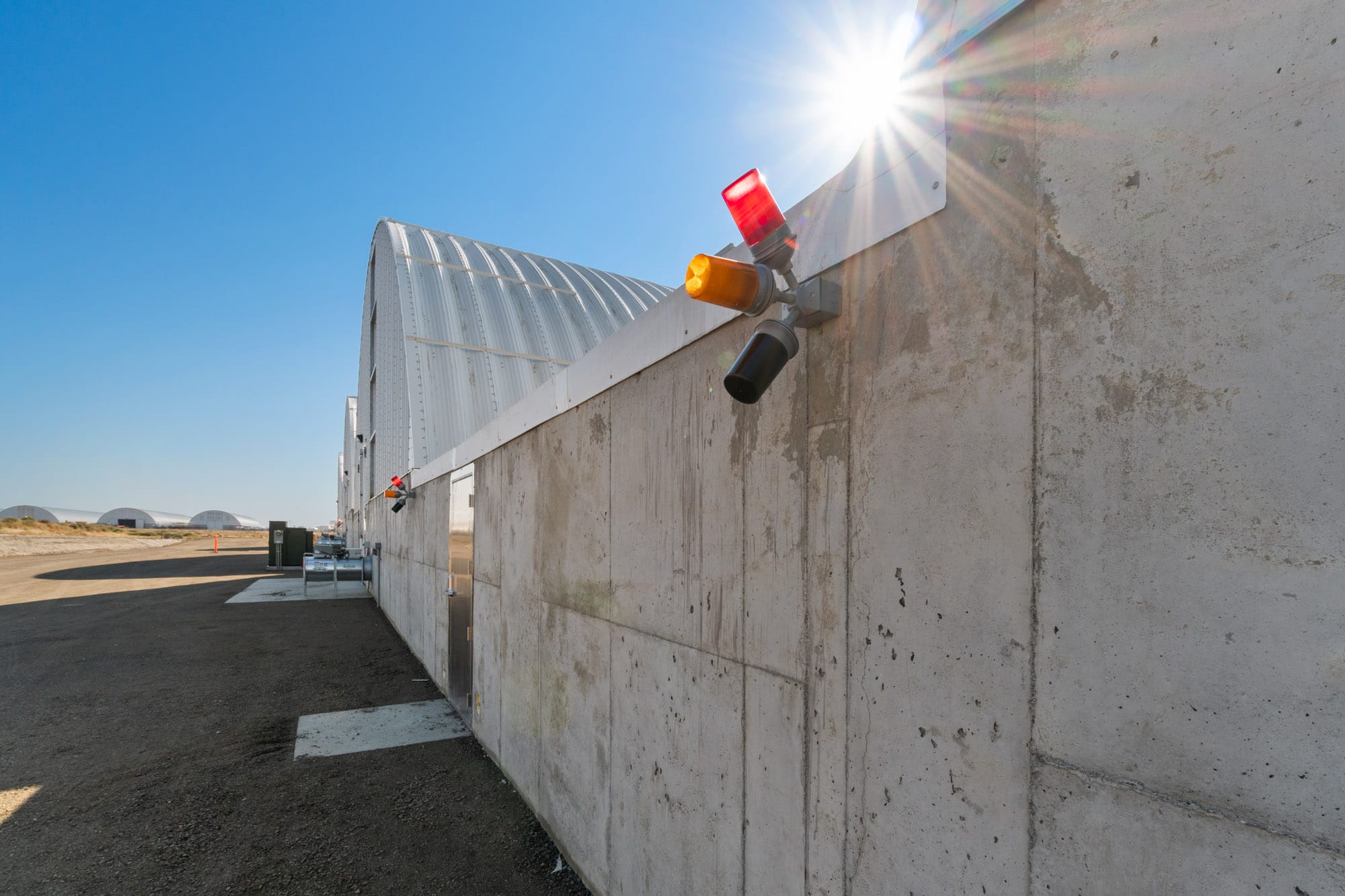 Industrial warehouse exterior with security lights and sunbeam.