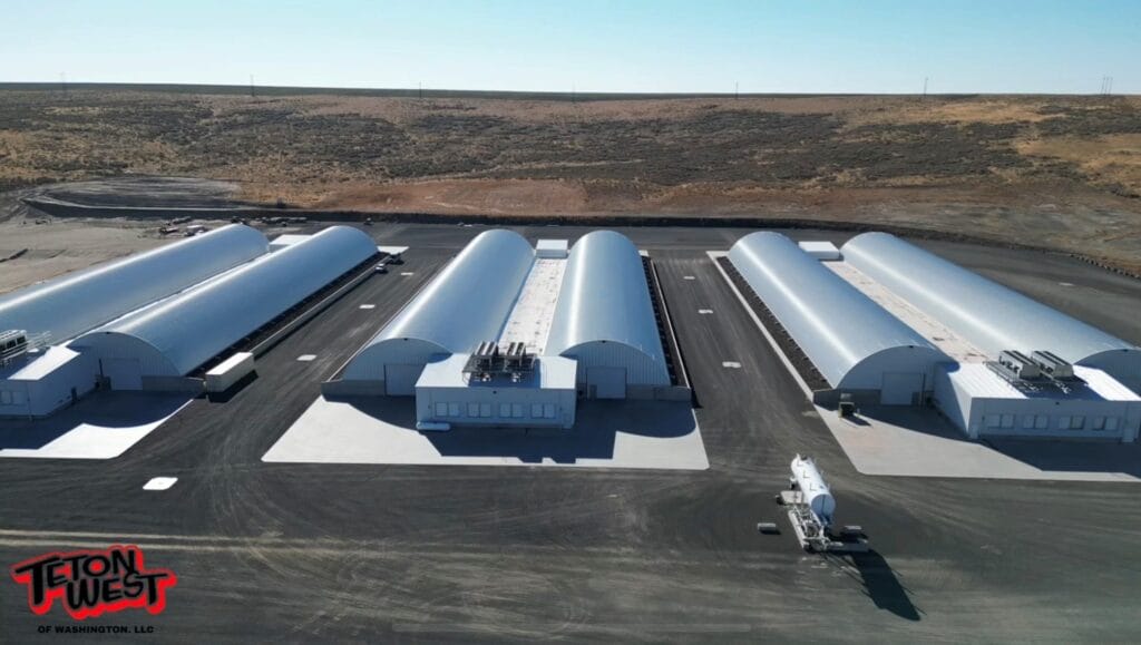Aerial view of industrial warehouses in arid landscape.