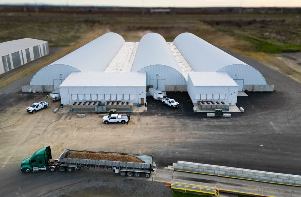 Industrial warehouse with trucks and trailer unloading cargo.