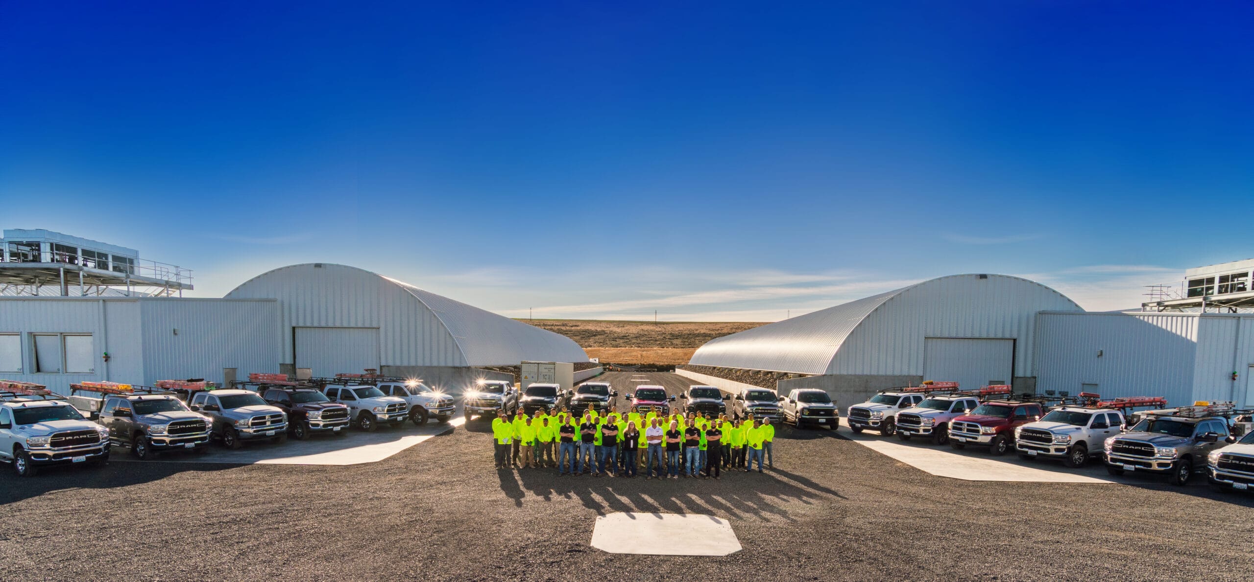Group in front of facility with trucks parked