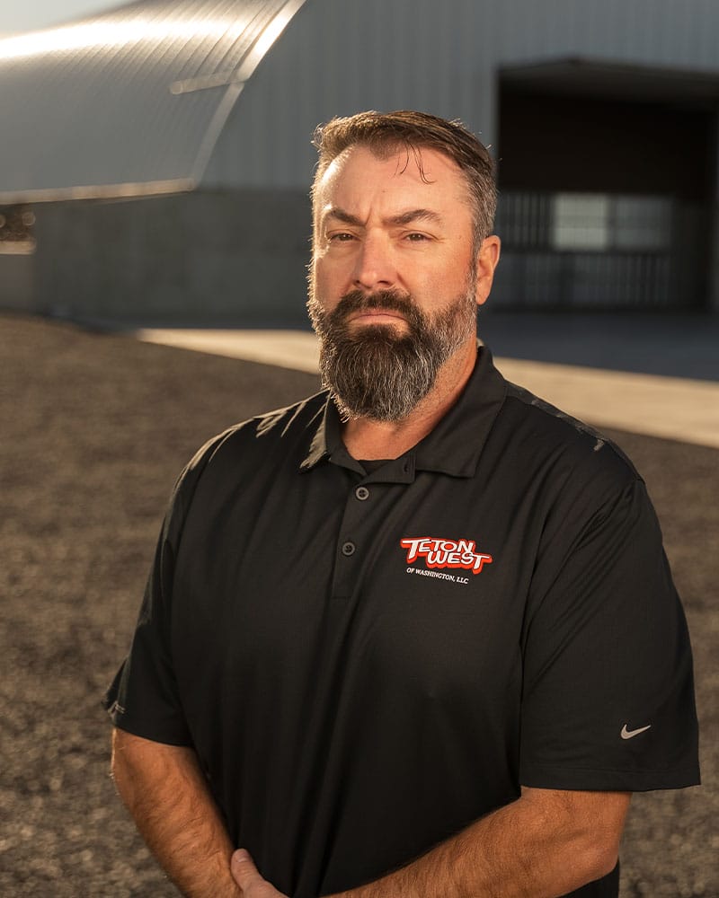 Man standing in front of a metal building.